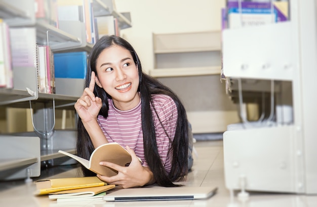 Libro di lettura asiatico della donna nella biblioteca