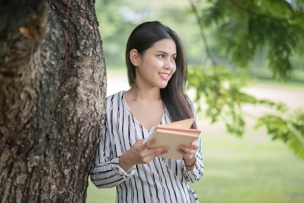 Libro di lettura bella donna nel parco verde