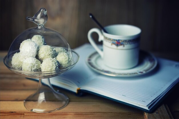 Libro di lettura con fiori di tè e dolci