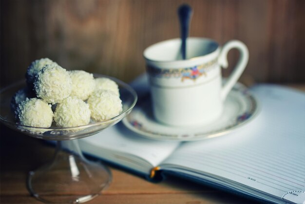 Libro di lettura con fiori di tè e dolci