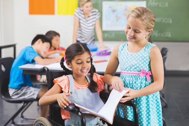 Libro di lettura dei bambini della scuola in aula