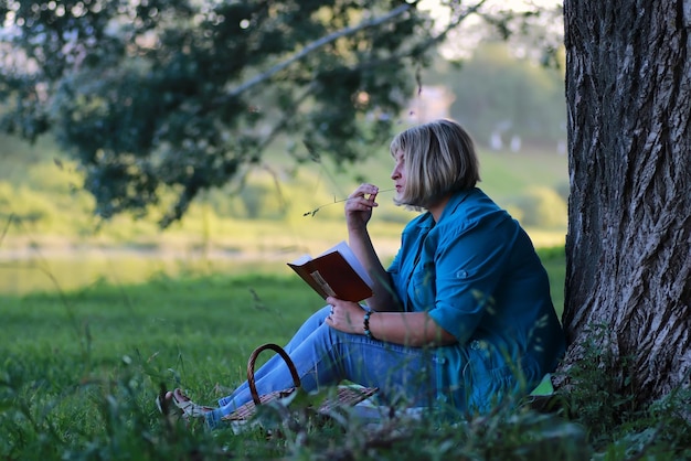 Libro di lettura dell'albero della donna nel parco