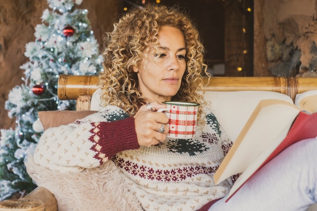 Libro di lettura della donna adulta durante le vacanze di Natale a casa