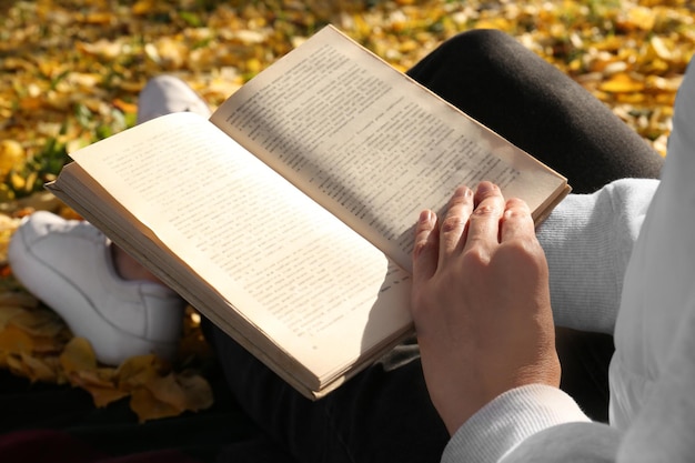 Libro di lettura della donna all'aperto il primo piano di giorno di autunno