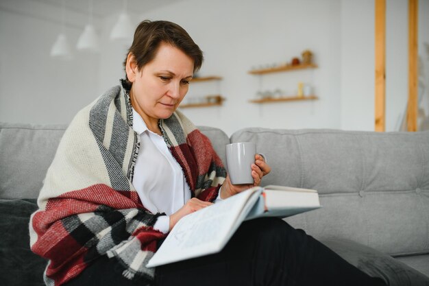 Libro di lettura della donna maggiore a casa