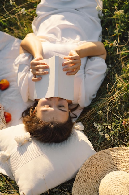 Libro di lettura della giovane donna nel campo all'aperto Lettura e relax Ora legale