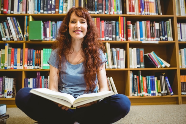 Libro di lettura maturo dello studente in biblioteca