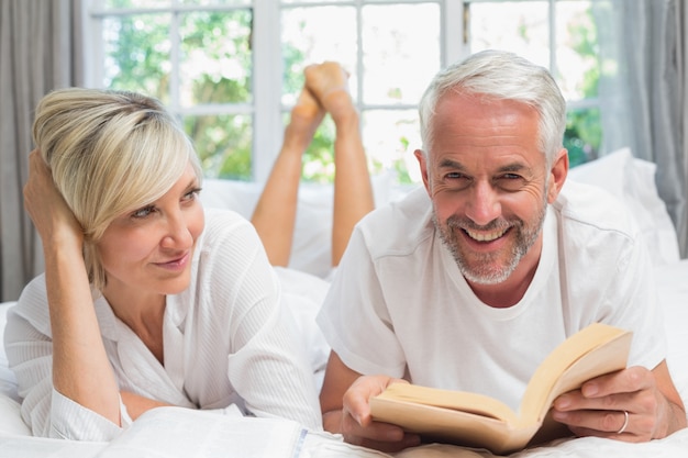 Libro di lettura maturo felice delle coppie a letto