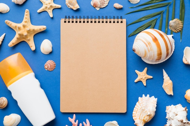 Libro di scrittura in bianco con accessori da spiaggia estivi su sfondo spazio per la copia Piatto con spazio per la copia