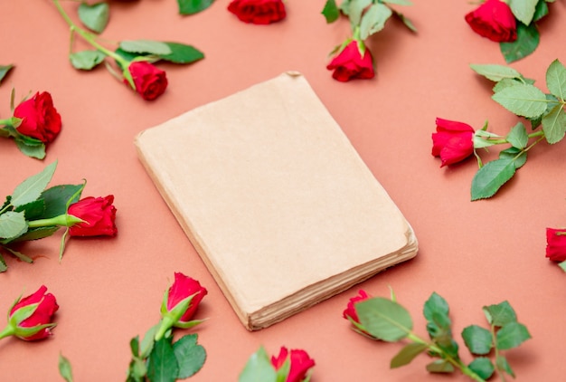 Libro e rose rosse intorno al rosa