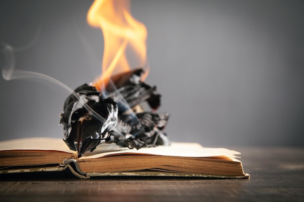 Libro in fiamme sul tavolo di legno