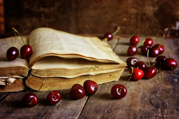 Libro retrò su fondo in legno e bacche di ciliegio