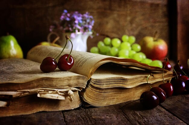 Libro retrò su fondo in legno e bacche di ciliegio