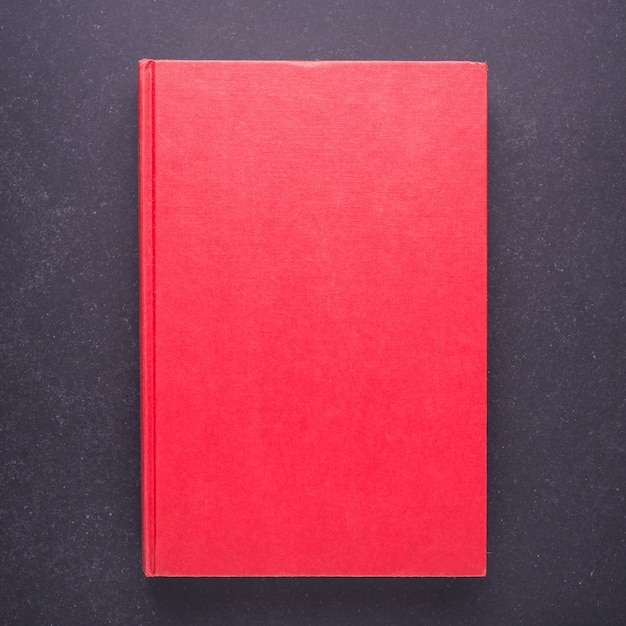 Libro rosso con coperchio vuoto vuoto su priorità bassa nera della tabella di pietra. Vista dall&#39;alto