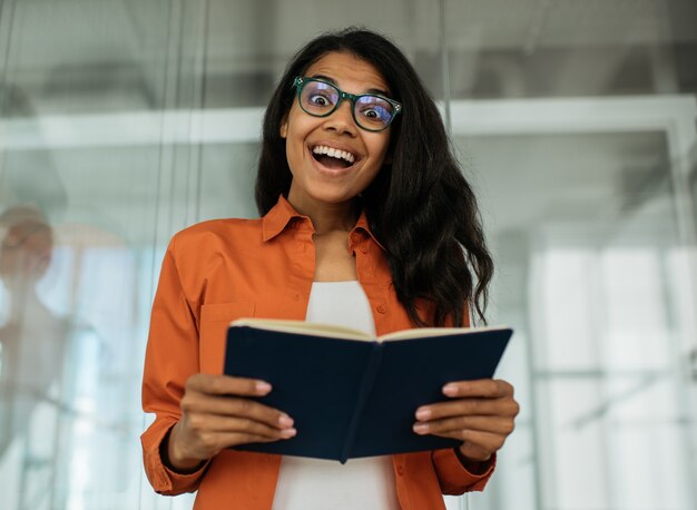 Libro sorridente della tenuta dello studente che studia il concetto di educazione linguistica di apprendimento