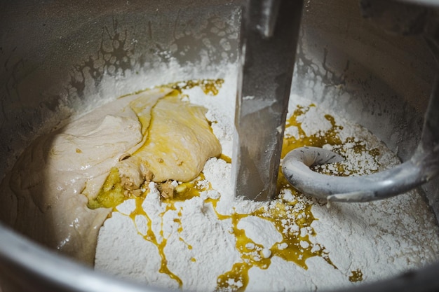 Lievito di farina a lievitazione naturale e olio d'oliva mescolati in un'impastatrice in una panetteria
