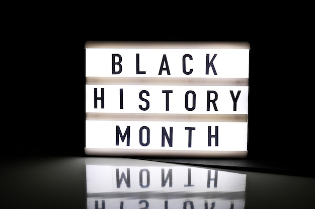 Lightbox con testo BLACK HISTORY MONTH su sfondo nero scuro con riflesso a specchio. Evento storico del messaggio. Leggero