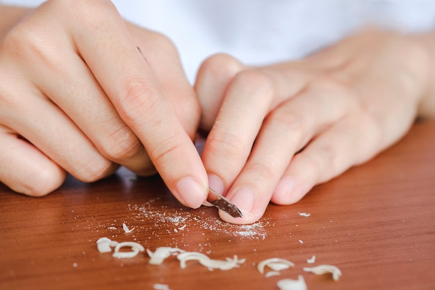 Lima per unghie a mano di una donna dopo aver tagliato le unghie. Il concetto di assistenza sanitaria dell'unghia.