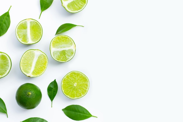 Lime fresche con foglie verdi su sfondo bianco