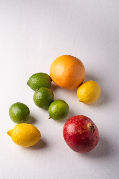 Lime, limone, pompelmo e melograno su bianco