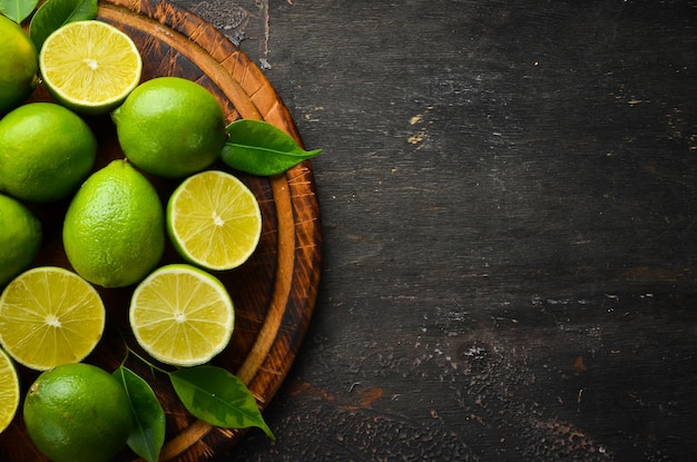 Lime verdi fresche con foglie Agrumi Su uno sfondo di pietra nera Vista dall'alto Spazio libero per il testo