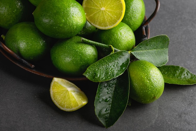 Lime verdi fresche con foglie su un vassoio