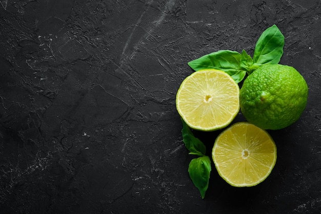 Limes verdi freschi Limone su sfondo nero Vista dall'alto Spazio libero per la copia