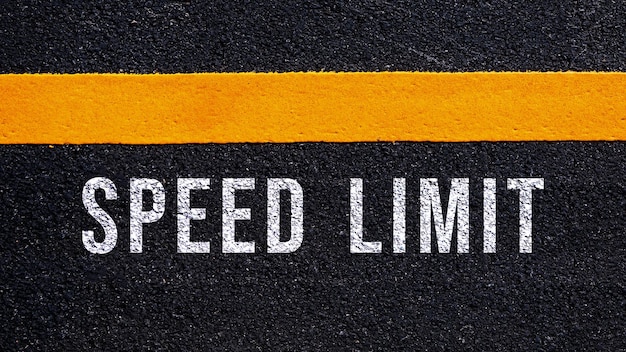 Limite di velocità scritto e linea gialla sulla strada in mezzo alla strada asfaltata Parola di limite di velocità sulla strada