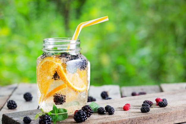 Limonata cocktail da arancia e bacche in barattolo di vetro