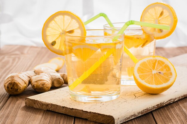 Limonata con limone e zenzero in bicchieri trasparenti su un tavolo di legno