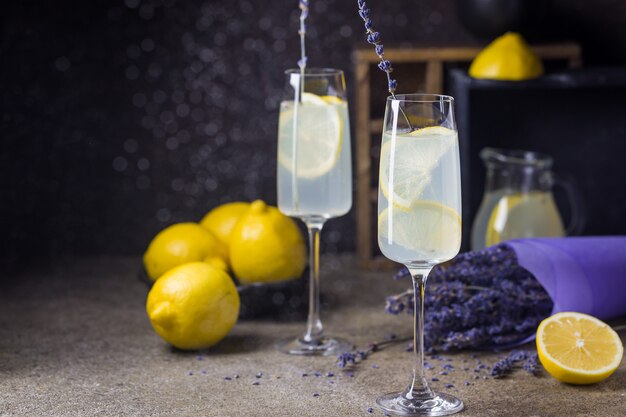 Limonata con limoni e lavanda sul tavolo di pietra nera