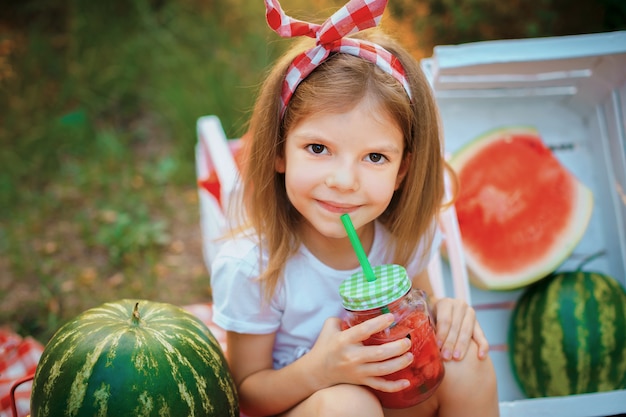 Limonata dell'anguria bevente del bambino in barattolo con ghiaccio e la menta come bevanda rinfrescante di estate