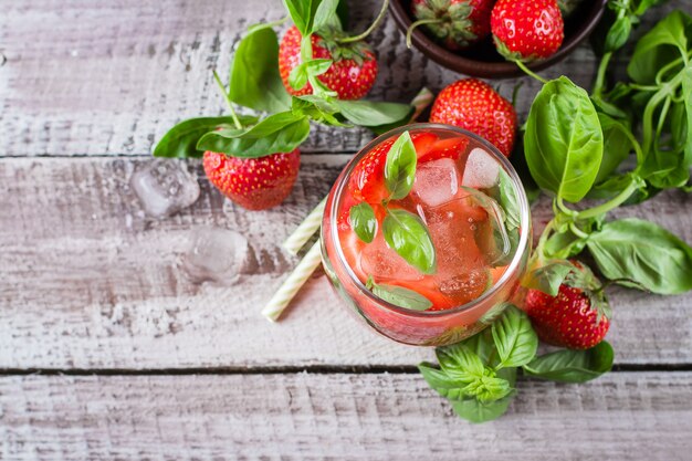 Limonata della fragola con basilico in vetro su fondo di legno. Vista dall&#39;alto, copia spazio