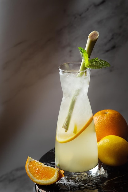 Limonata di agrumi con citronella e ingredienti vicino al tavolo di marmo. limonata in caraffa con ghiaccio