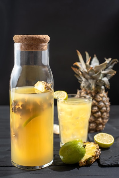 Limonata di ananas fermentata su una cornice verticale di sfondo nero