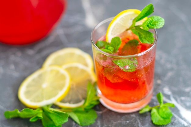 Limonata fatta in casa con fragole, menta e brocca di limone e bicchiere con cocktail rinfrescante estivo