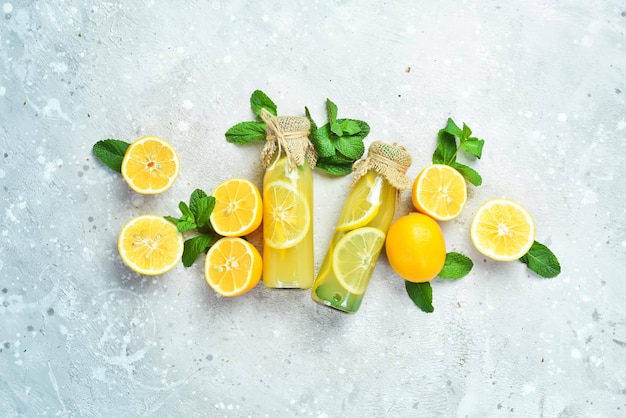 Limonata fatta in casa con menta e miele in una bottiglia di vetro. Concetto di bevanda sana di vitamina. Su uno sfondo di pietra.