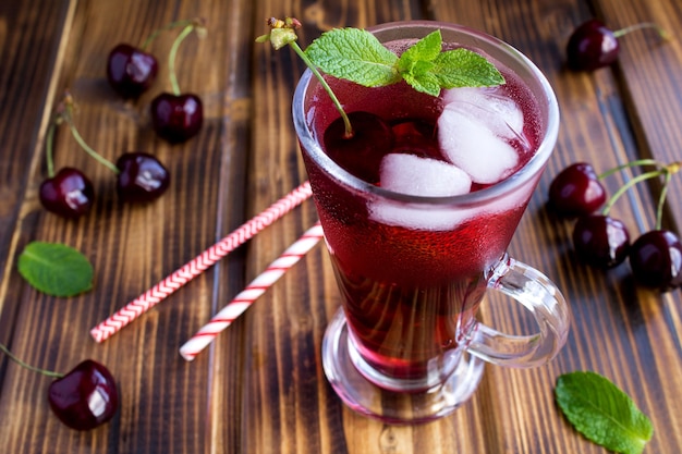 Limonata fredda con ciliegie nel bicchiere