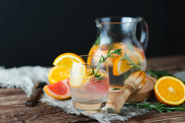 Limonata fresca estiva con pompelmo e rosmarino su un vecchio tavolo di legno. Concetto di estate.