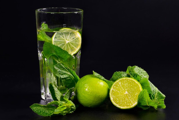 Limonata Mojito su sfondo nero Bevanda verde estiva con limone lime e menta