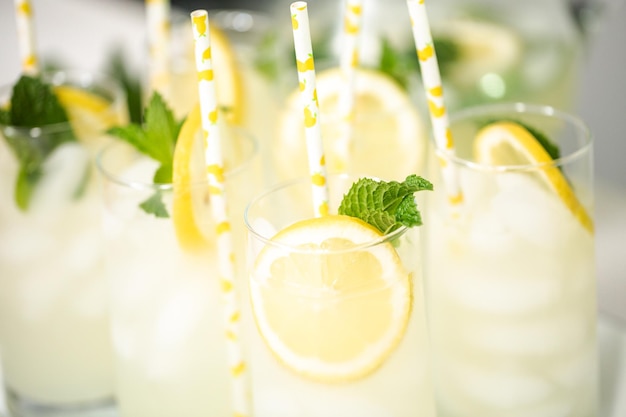 Limonata tradizionale con una fetta di limone fresco e menta con cannuccia di carta nel bicchiere.