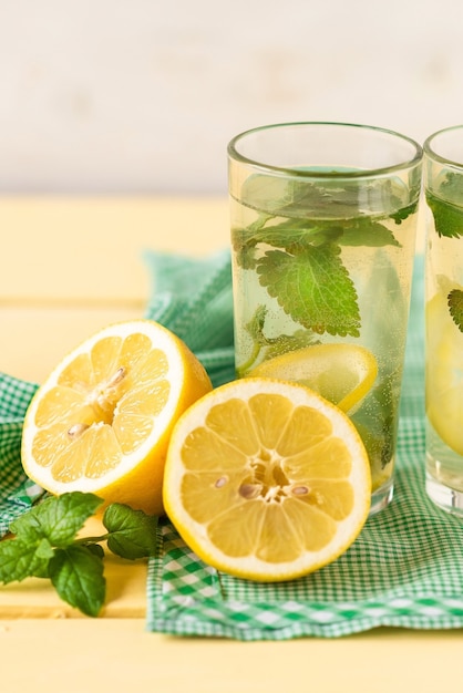 Limone a fette con un bicchiere di limonata fresca.