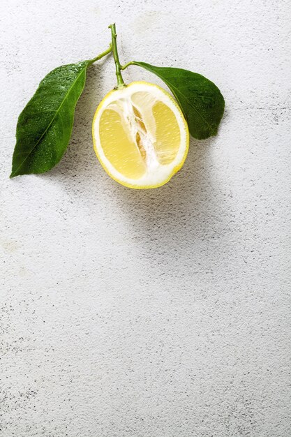 Limone affettato su una tavola di pietra bianca con le foglie.