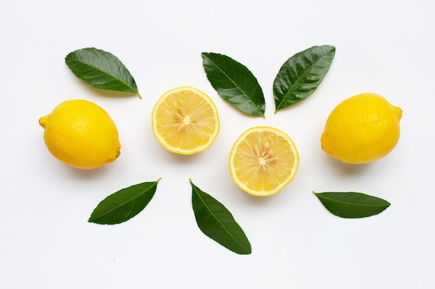 Limone e fette con foglie isolate su bianco.