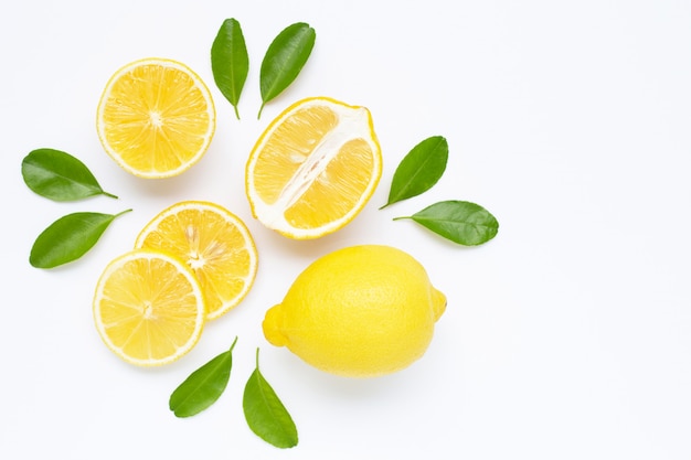 Limone e fette con foglie isolate su bianco.