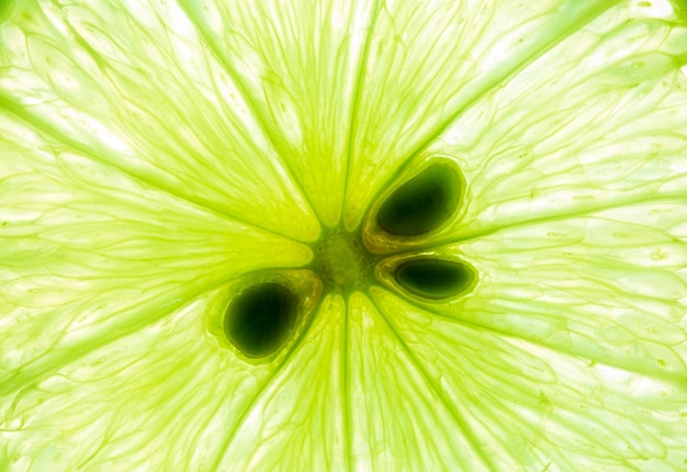 Limone e lime verde fette sovrapposte primo piano sfondoMacro close up texture di superficie Juicy