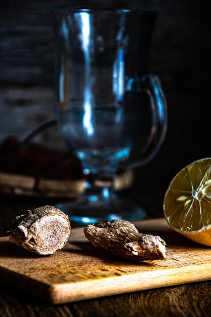 Limone e zenzero su un tagliere per preparare il tè medicinale.