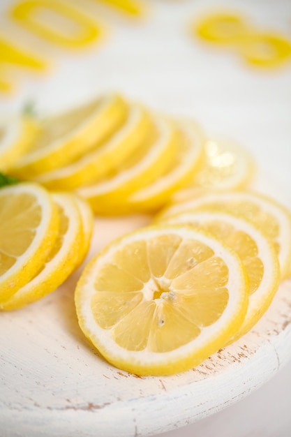 Limone fresco affettato su un tagliere di legno bianco.