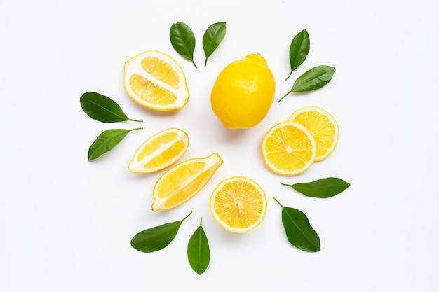 Limone fresco con le foglie verdi su bianco.