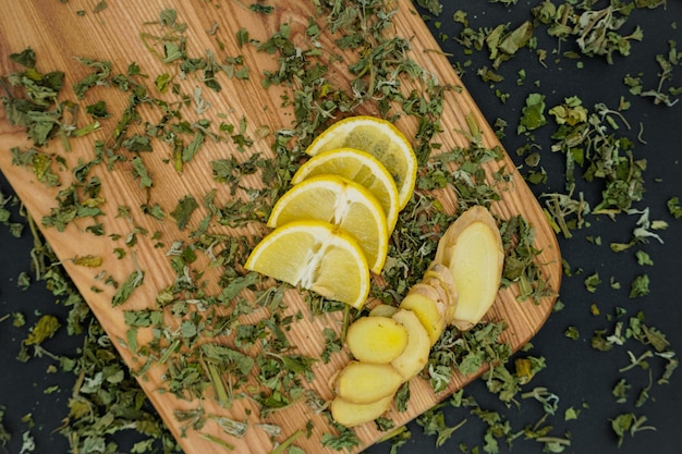 Limone fresco con lo zenzero su fondo di legno. Menta secca. Ingredienti per il tè verde.